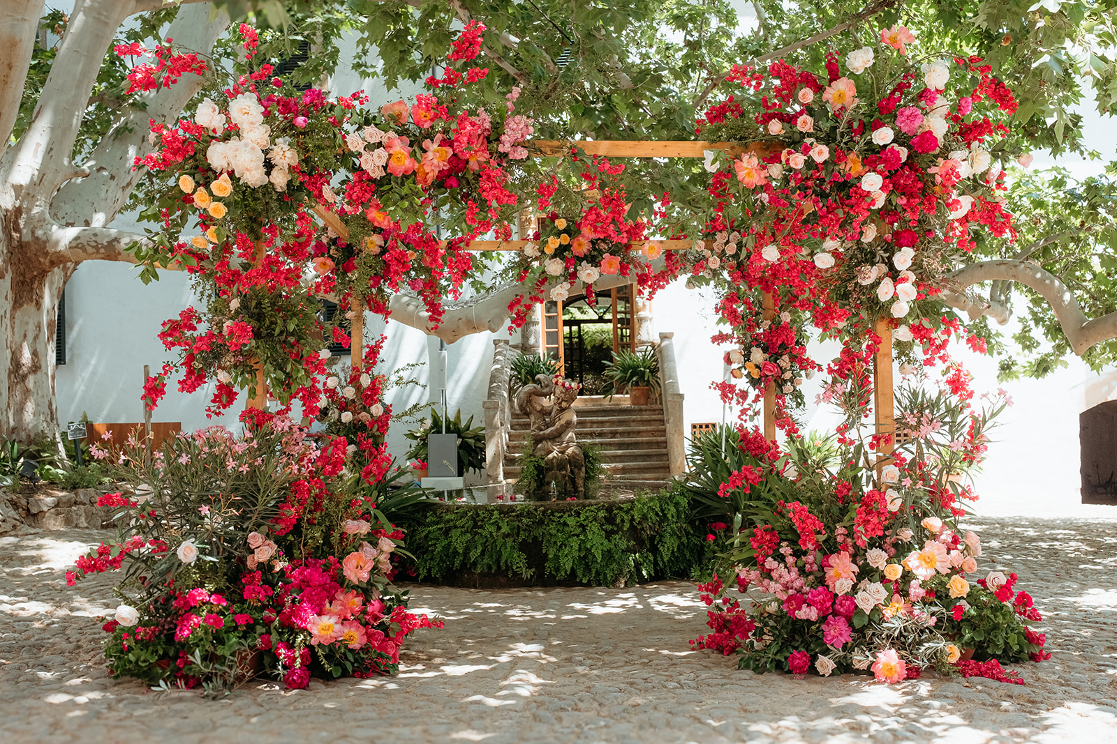 Jardines de Alfabia Wedding Mallorca Violeta Minnick Photography Red Pink Cream Orange Natural Flower Arch Backdrop