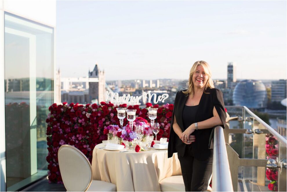 Proposal in London, florals created by Paula Rooney who standing in front of her flower wall backdrop overlooking London Bridge