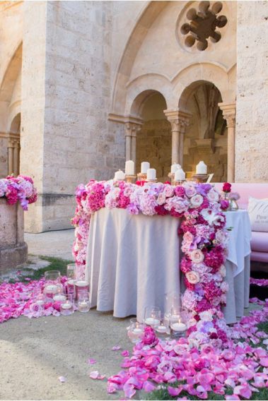 Luxury destination wedding in Spain at the stunningCastilla Termal Monasterio De Valbuena. this photo shows the luxury top table with a garland of roses accross the top and trailing down