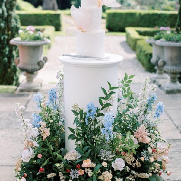 Pastel summer woodland medow wedding flowers around the three tiered cake by MonAnnie cakes